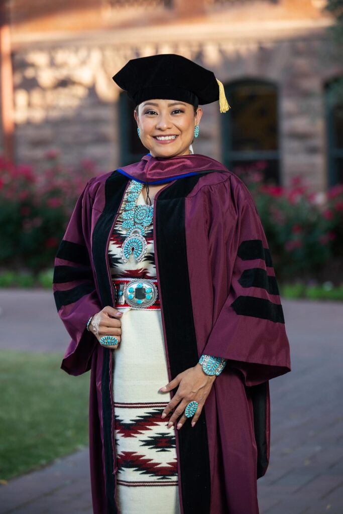 Brianne Arviso wearing a traditional Navajo rug dress along with her gown for the Spring 2022 ceremony.